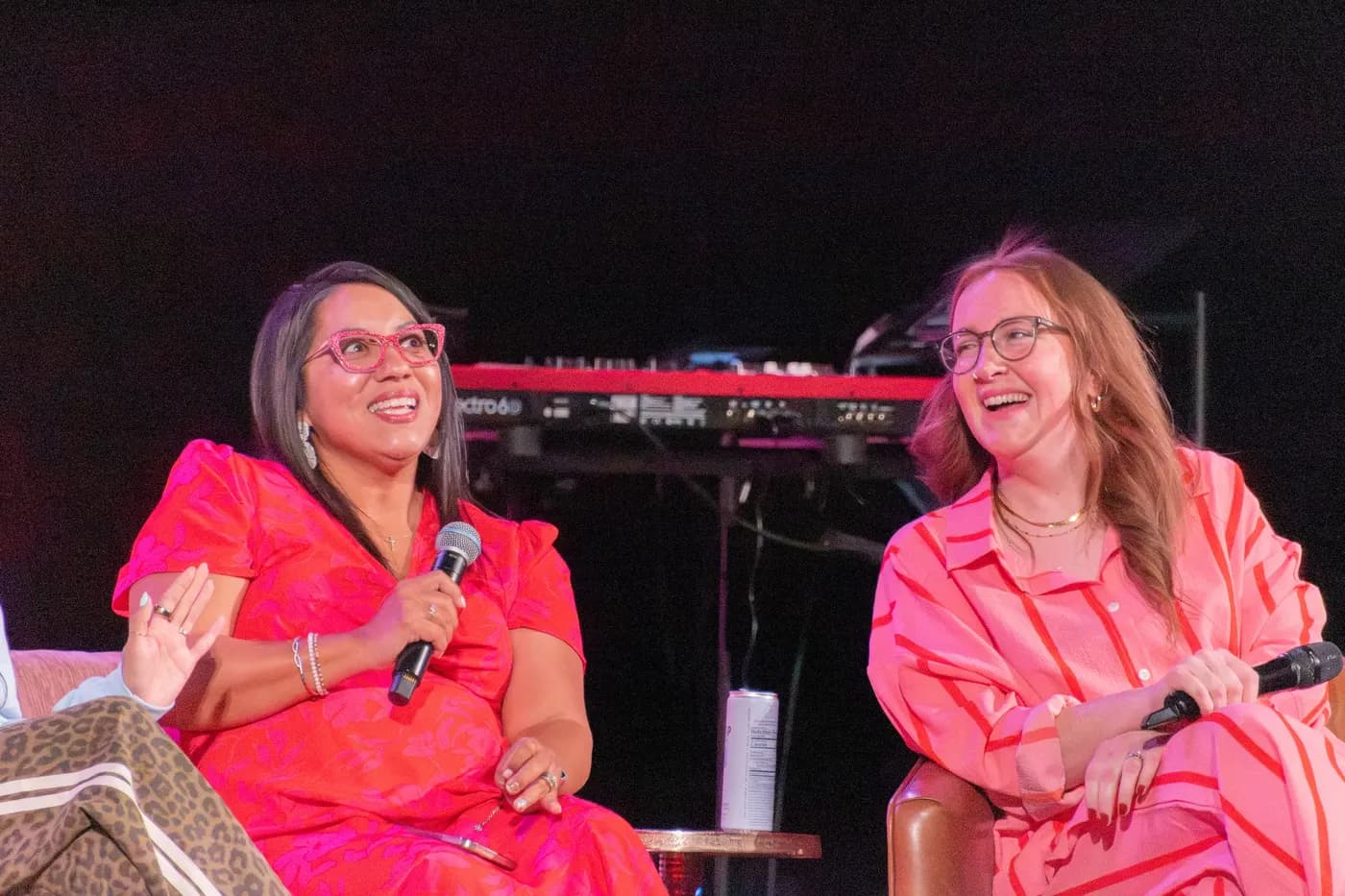 Two women laughing together on stage during a Crowned conversation