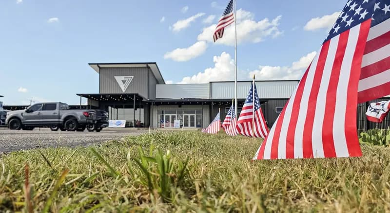 The Vintage Church Harker Heights building on a sunny day, with American flags along the lawn out front