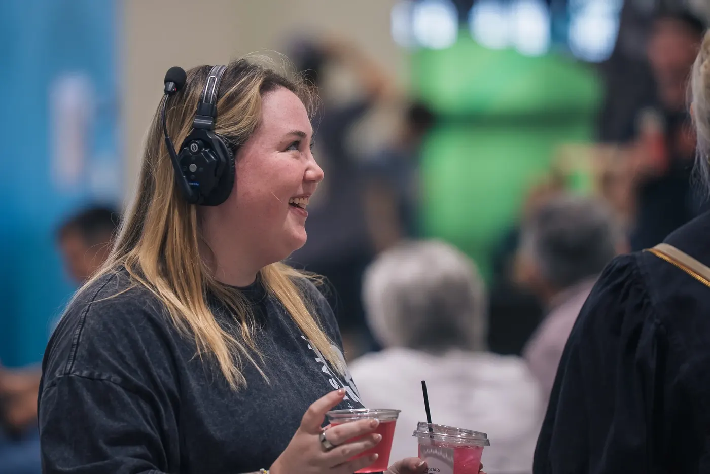A smiling volunteer in a headset welcoming people as they arrive