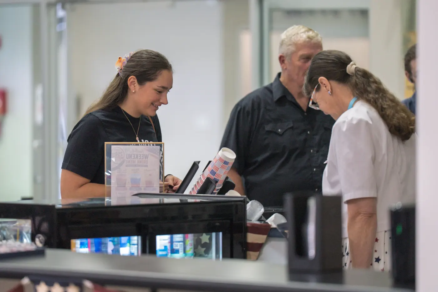 A volunteer welcoming guests at the Guest Suite desk after the service
