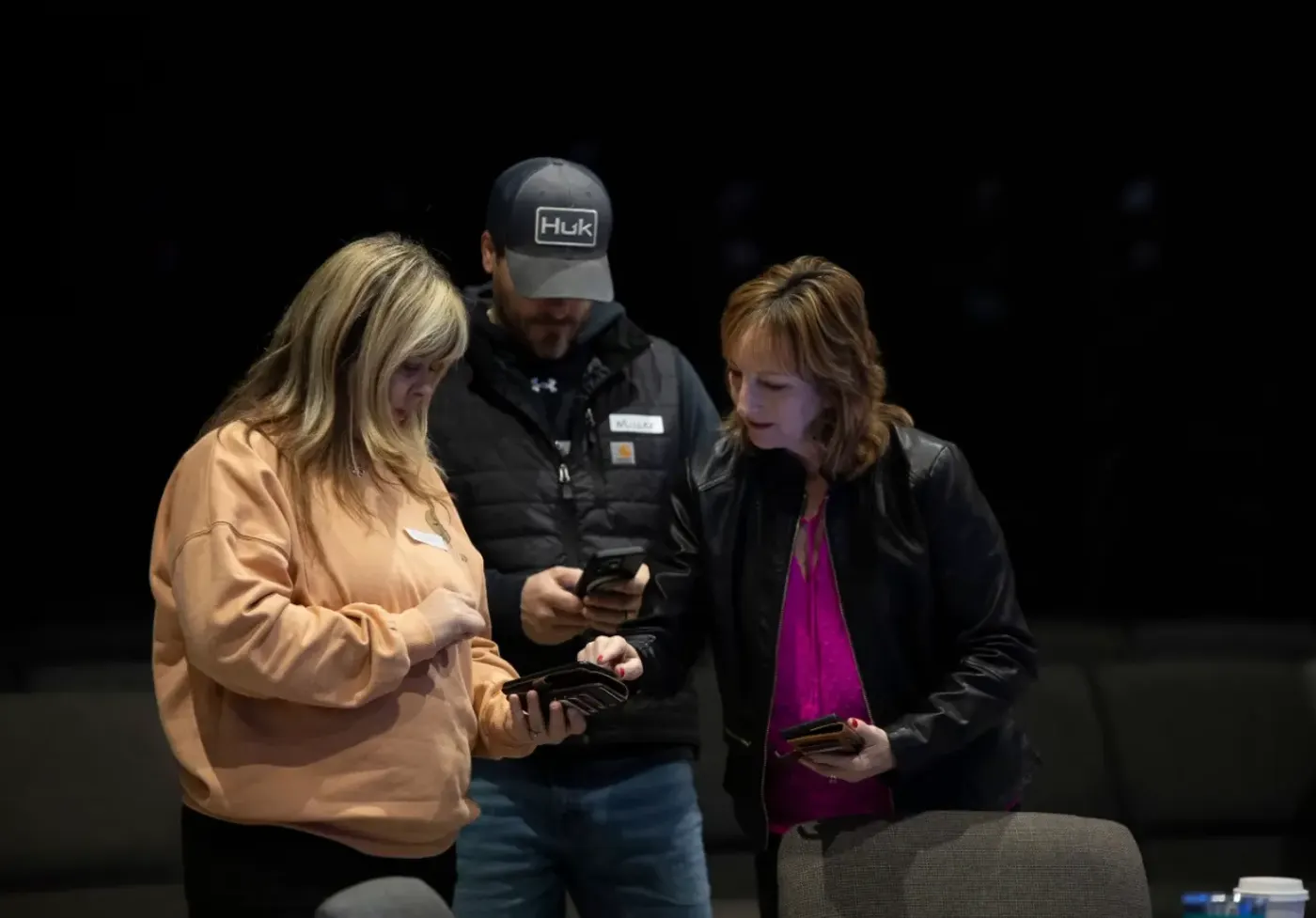 Three operations volunteers checking a schedule on their phones